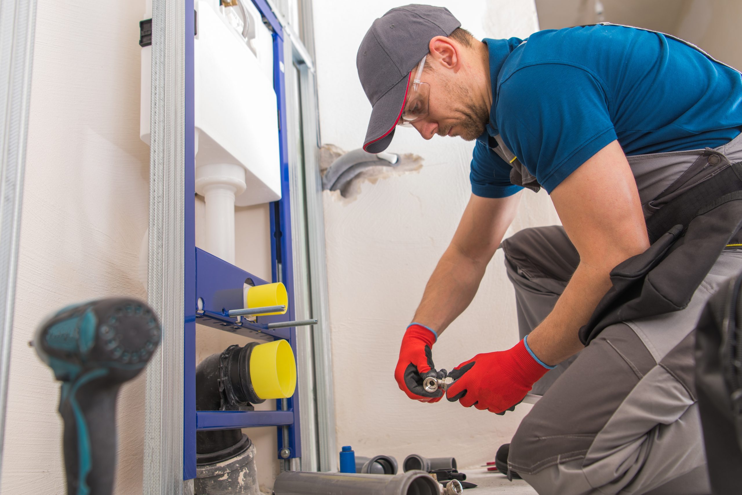 Caucasian Sanitary Plumbing Installer in His 30s Installing Bathroom Equipment.